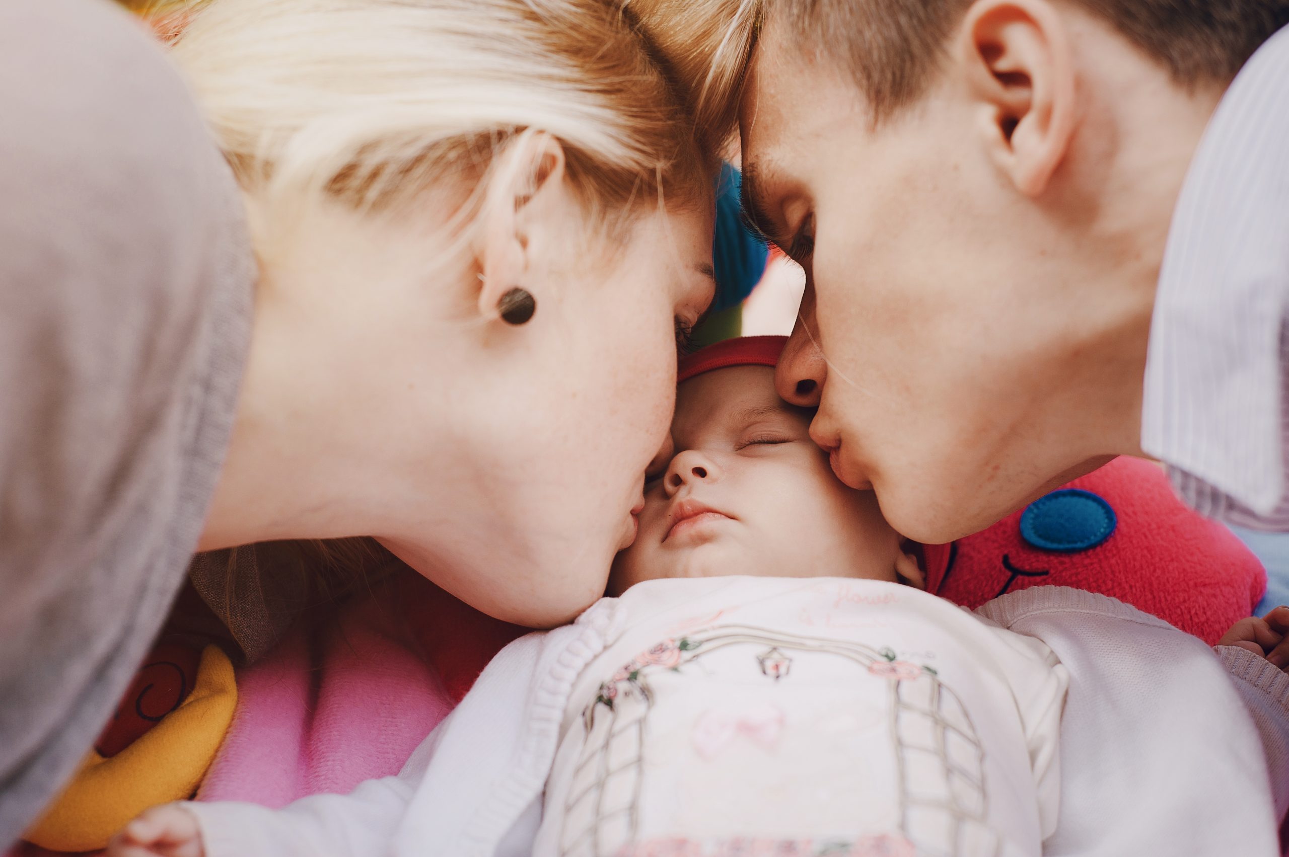 Couple kissing their daughter
